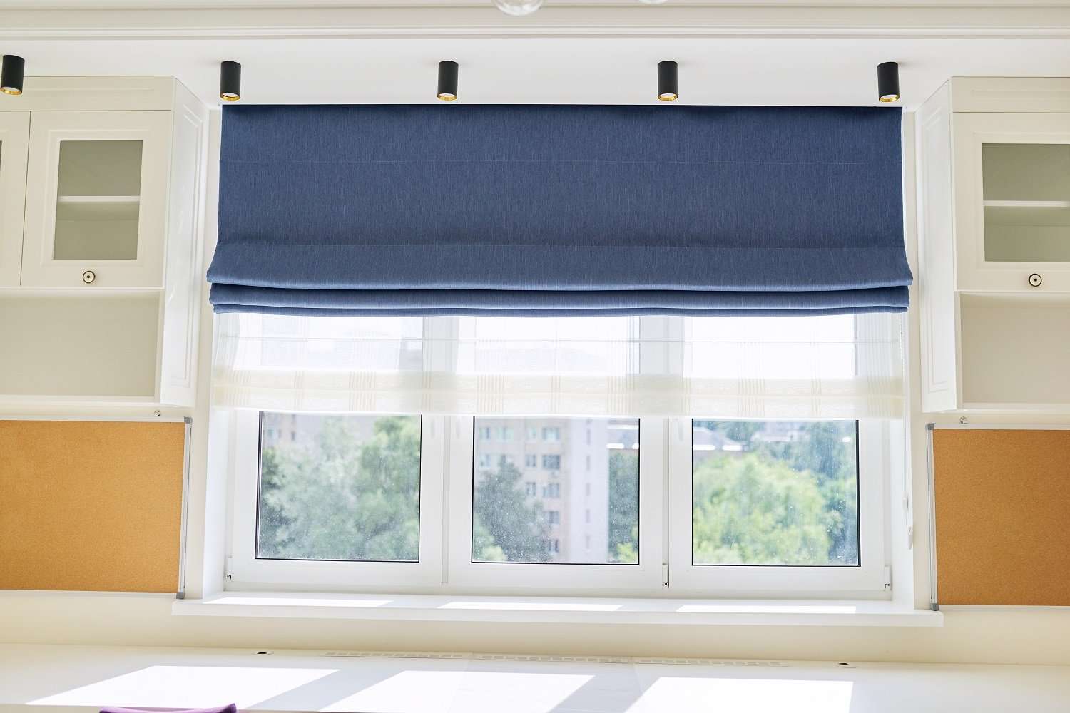 Shade.shop offers roman blinds Roman blind in the interior detail close-up. Curtain blue blackout fabric, sheers white linen, fashionable modern window decoration design at home