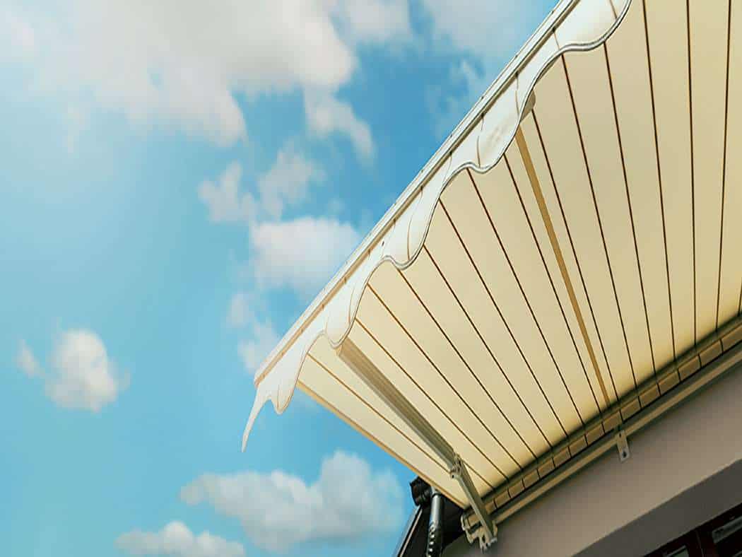 a-retractable-awning-with-blue-sky-behind-it - Shade.Shop A retractable awning with blue sky behind it