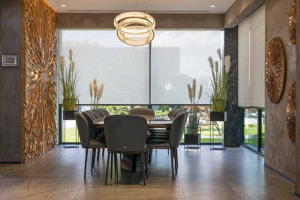 White roller blinds in a dining room in a luxury home