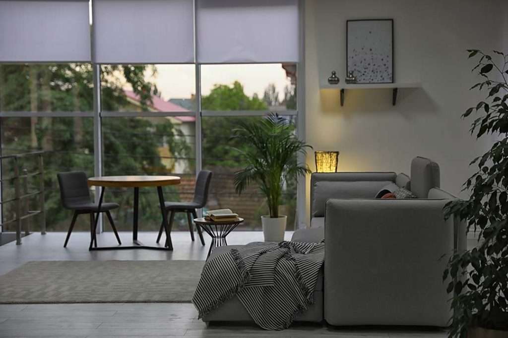 A cozy, contemporary living room with white window shades